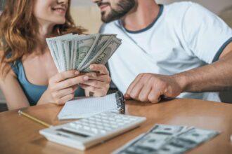 Man and woman sitting at table budgeting to fit their new financial goals
