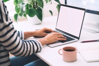 A remote worker, sitting at a desk and using a laptop to apply for jobs on the hidden job market.